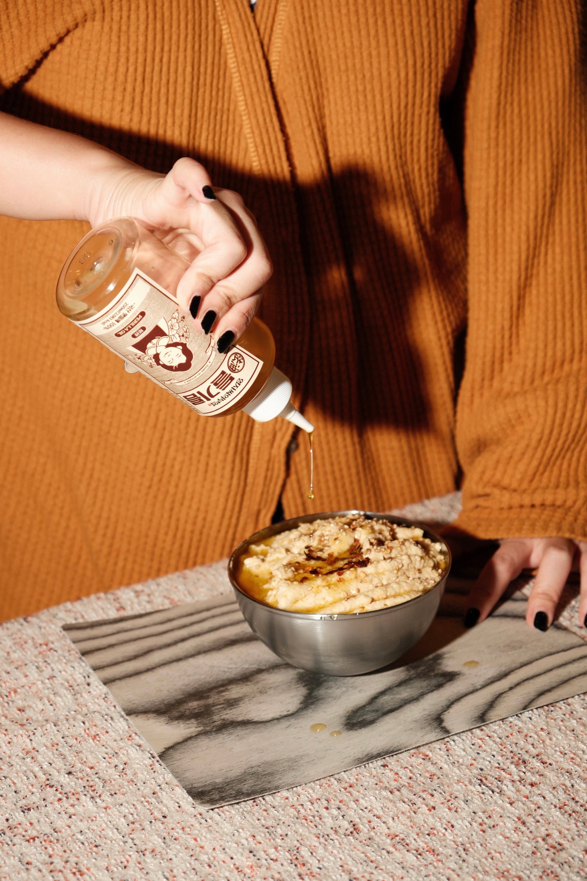 Person holding a bottle of Liquid Gold Youngja's Perilla Oil